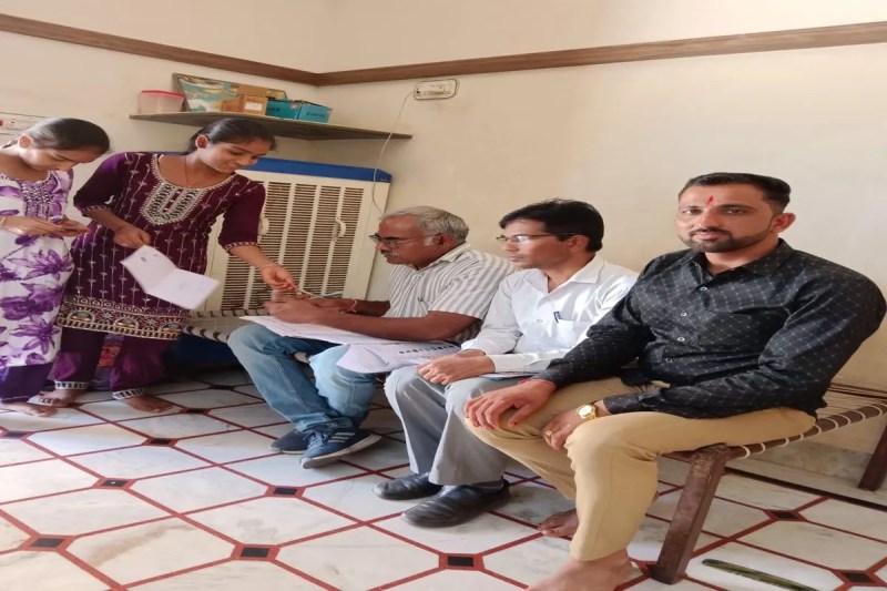 हाउस होल्ड सर्वे के तहत एक घर में जानकारी लेते शिक्षक।
