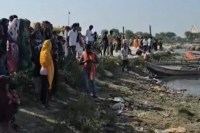 तलाश करती रेस्क्यू टीम नदी के किनारे खड़े लोग