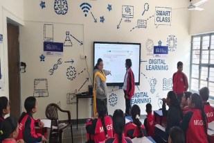 A teacher engages students in classroom learning at Mahatma Gandhi School, located in Indira Colony, Sri Ganganagar.