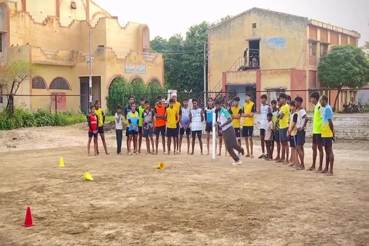 A coach teaching technical skills to an athlete and providing guidance during practice at the Maharaja Ganga Singh Sports Stadium in Sri Ganganagar