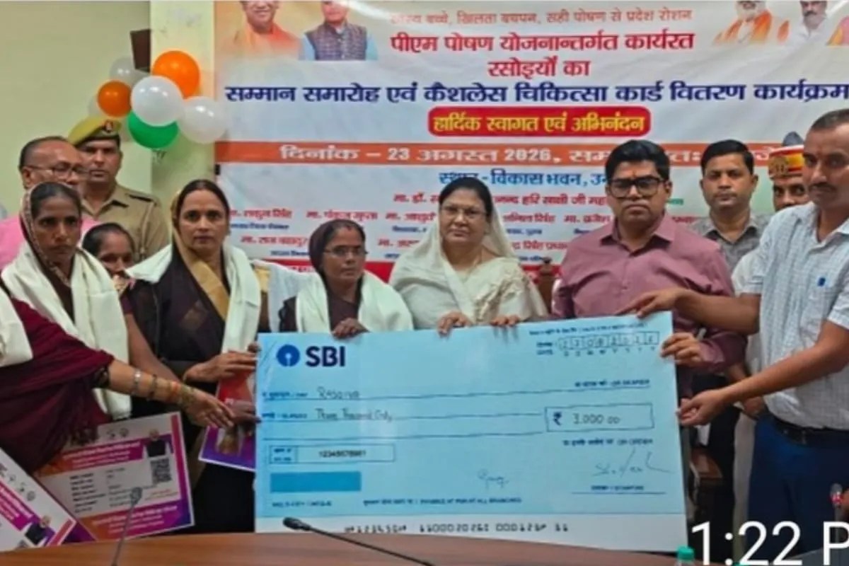 रसोइया को प्रतीकात्मक चेक देते जिला पंचायत अध्यक्ष शकुन सिंह और जिलाधिकारी घनश्याम मीणा, फोटो सोर्स- सूचना विभाग