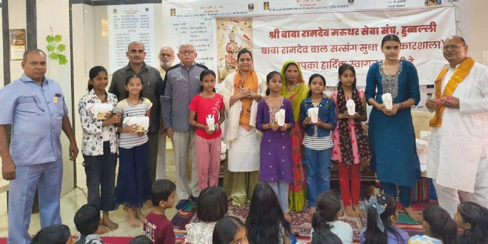 संस्कारशाला में कविता पाठ के बाद पुरस्कार प्राप्त करते बच्चे। साथ में आयोजक एवं अतिथि।
