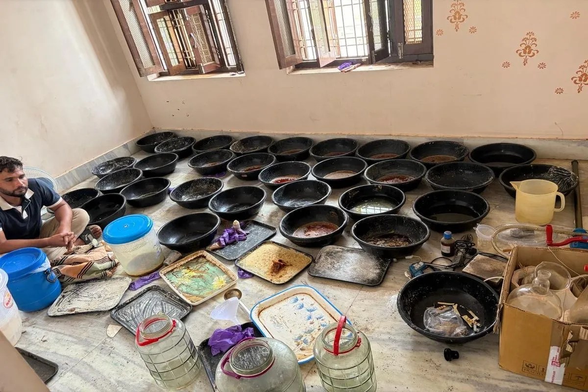 एमडीएमए फैक्टरी में प्लास्टिक के टब में तैयार की गई एमडी व पास में बैठा आरोपी