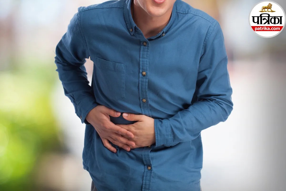 Person clutching upper abdomen in severe pain, acute pancreatitis symptom