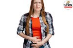 Person holding their upper right stomach in severe pain after eating a meal