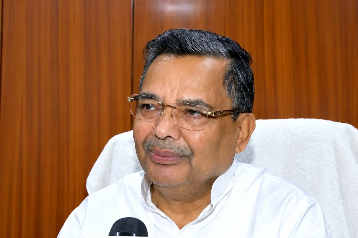 Jaiveer Singh sitting in a chair, wearing a white kurta and glasses