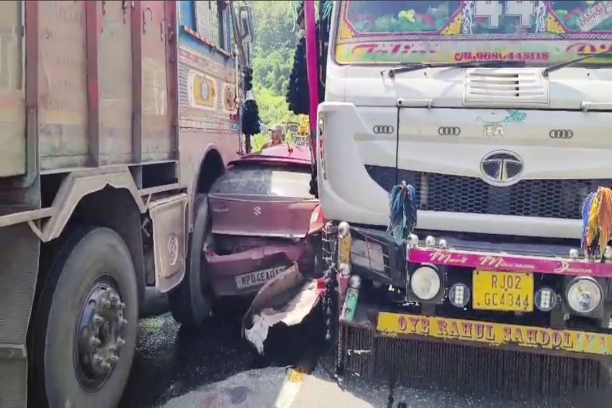 car trapped between two trucks