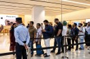 People waiting in a long queue at an Apple Store for iPhone 18