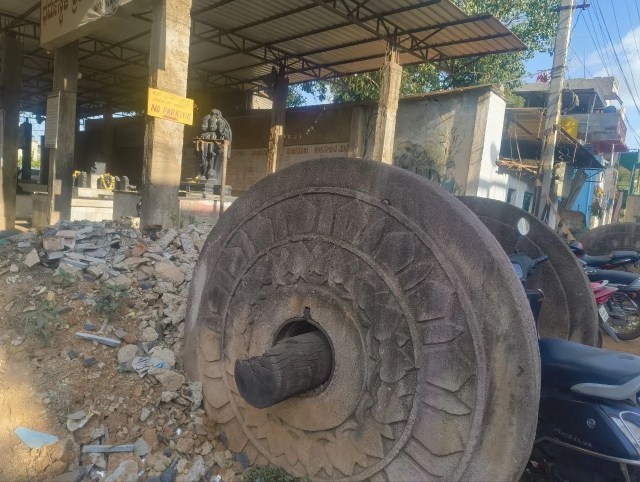 पुरानी परंपरा की निशानी: मंदिर परिसर के बाहर रखा पत्थर का पुराना रथ का पहिया।