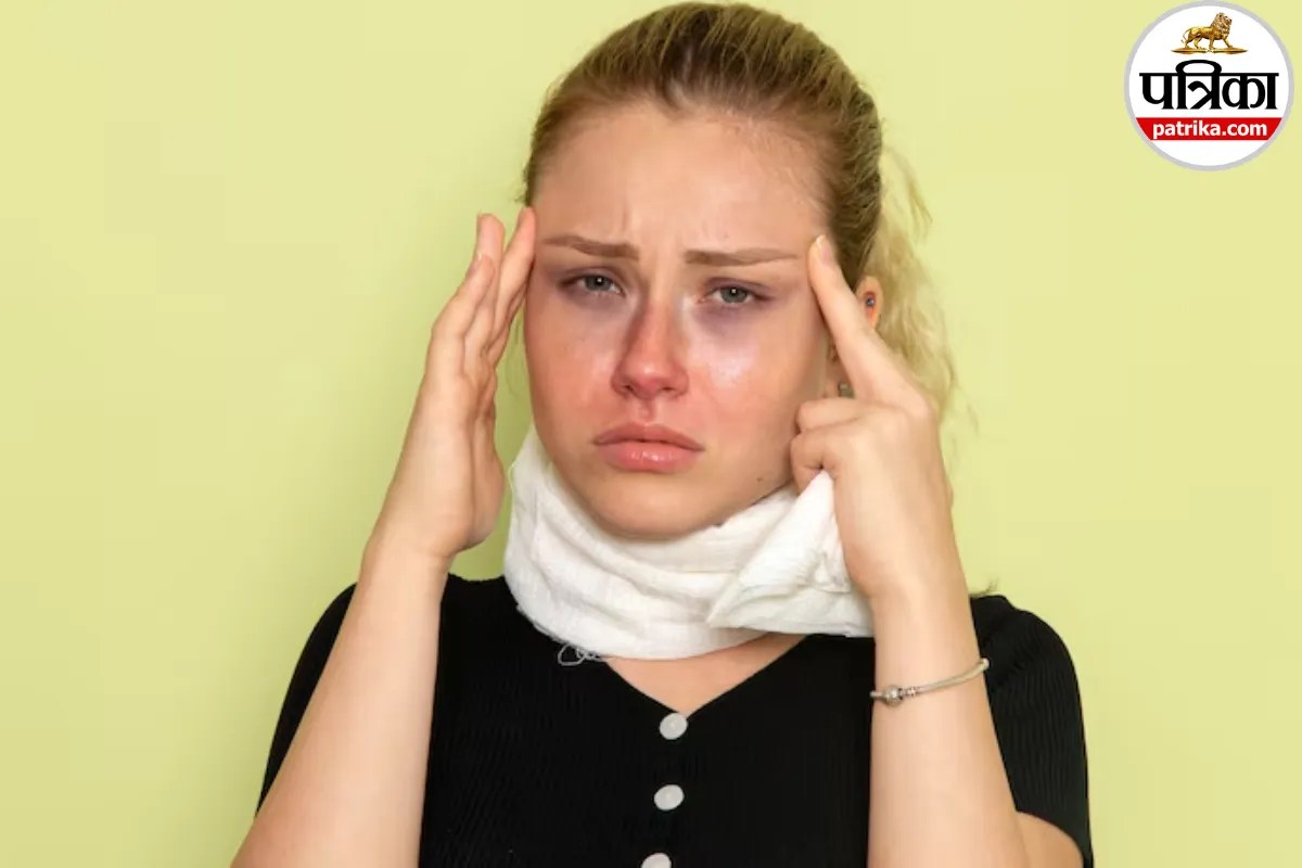 A person holding a hand against one side of their swollen cheek in pain due to a dental infection or facial swelling