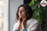 A person holding their throat feeling discomfort due to globus sensation or throat tightness.