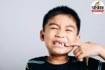A child experiencing severe leg and bone pain holding his shin in discomfort