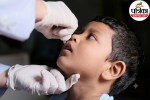 Healthcare worker giving two drops of oral polio vaccine (OPV) to a child during the Pulse Polio campaign