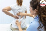 Doctor checking patient suffering from back pain