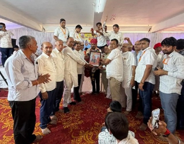 नरसिंह वीरधाम लूणावास के वागाराम चौधरी भोपाजी को तस्वीर भेंट करते आयोजक।